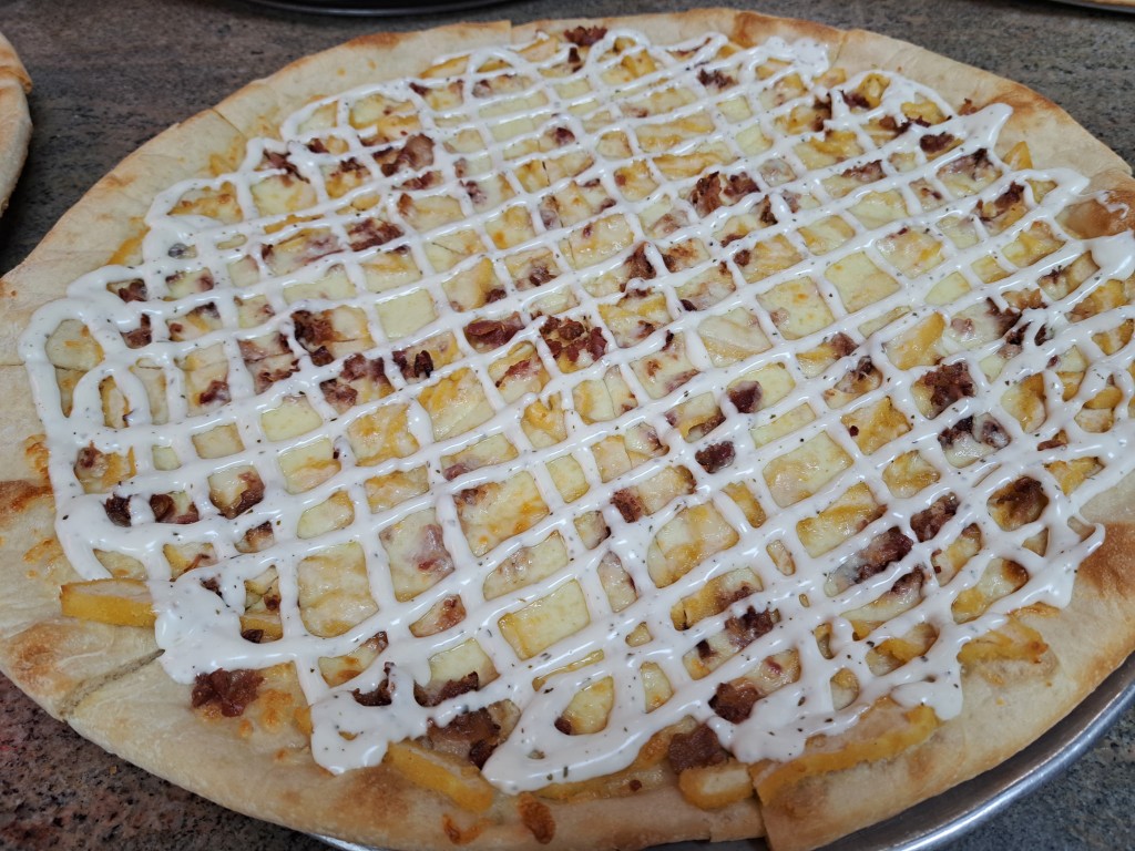 Specialty pizza with ranch drizzle at Frank's Pizza Oak Ridge